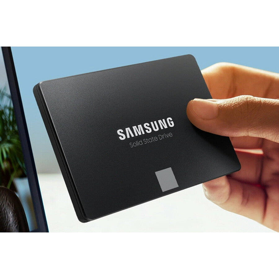 Black Samsung SSD held in hand with logo and label visible