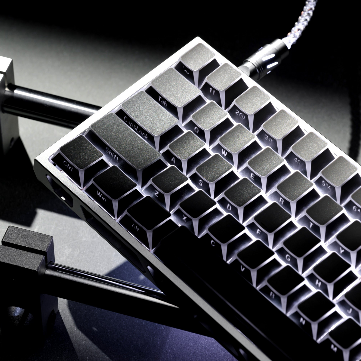 Close-up of grey PBT keycaps with shine-through translucent legends on a keyboard