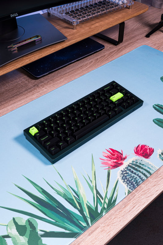 Blue cactus desk mat with keyboard placed on top, featuring cactus and flower artwork