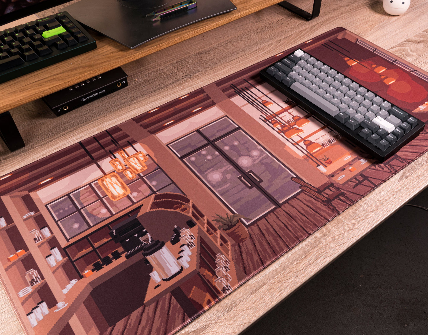 Desk mat corner with keyboard on coffee shop artwork and light wood trim