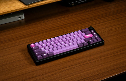 Purple octopus-themed keycaps keyboard on a wood desk, angled view.