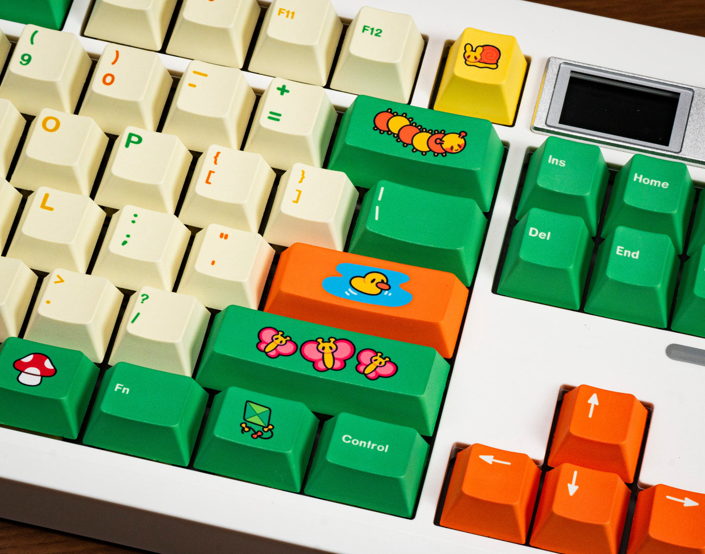 Close-up keycaps: green control keys and orange function keys with cartoon icons