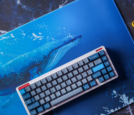 Desk mat with wide blue whale graphic and stitched edges