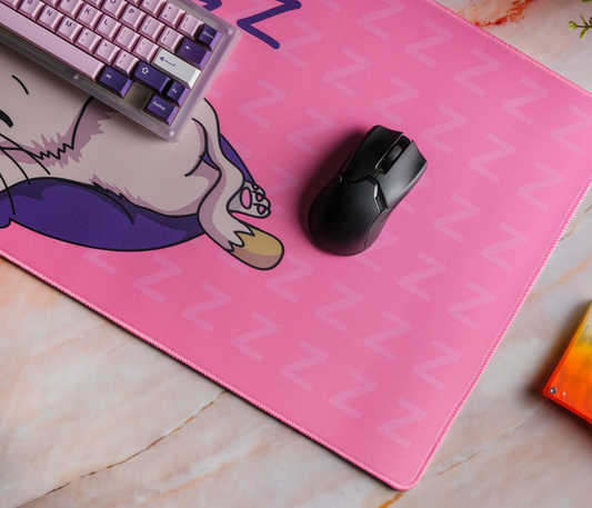 Pink desk mat showing sleeping kitten paws and mouse on ZZZ background, stitched edge