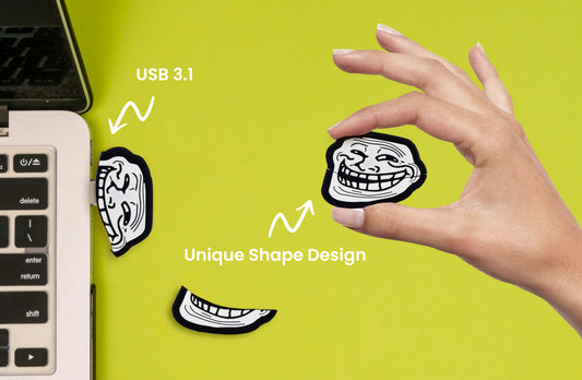 Troll face USB flash drive held in a hand, black body with white graphic and gold tip