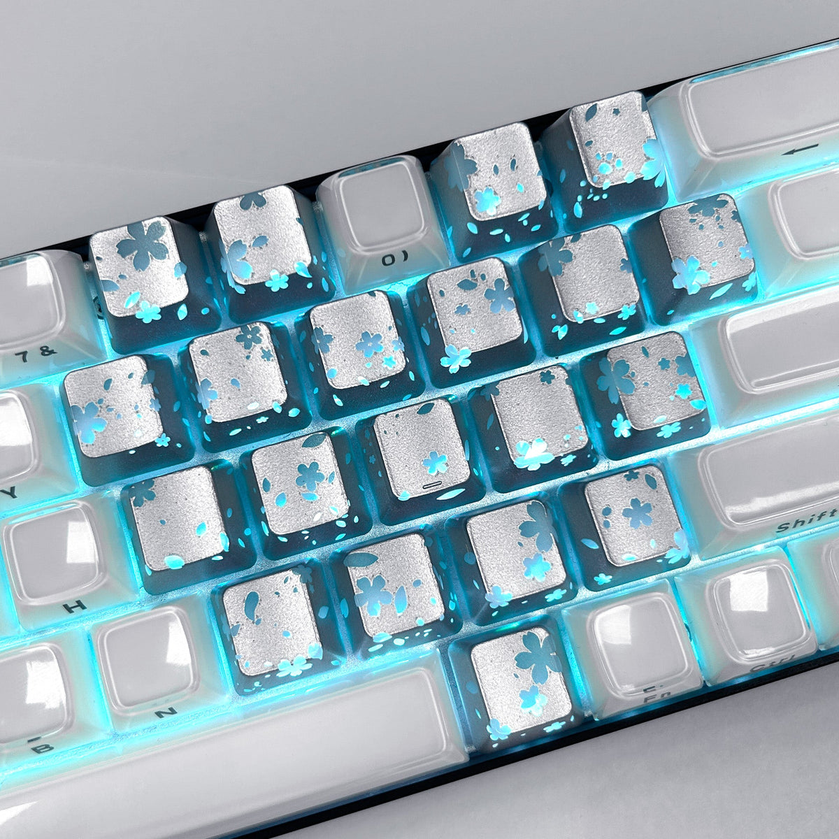 White keycaps with blue backlight and blossom-style flower cutouts on squares