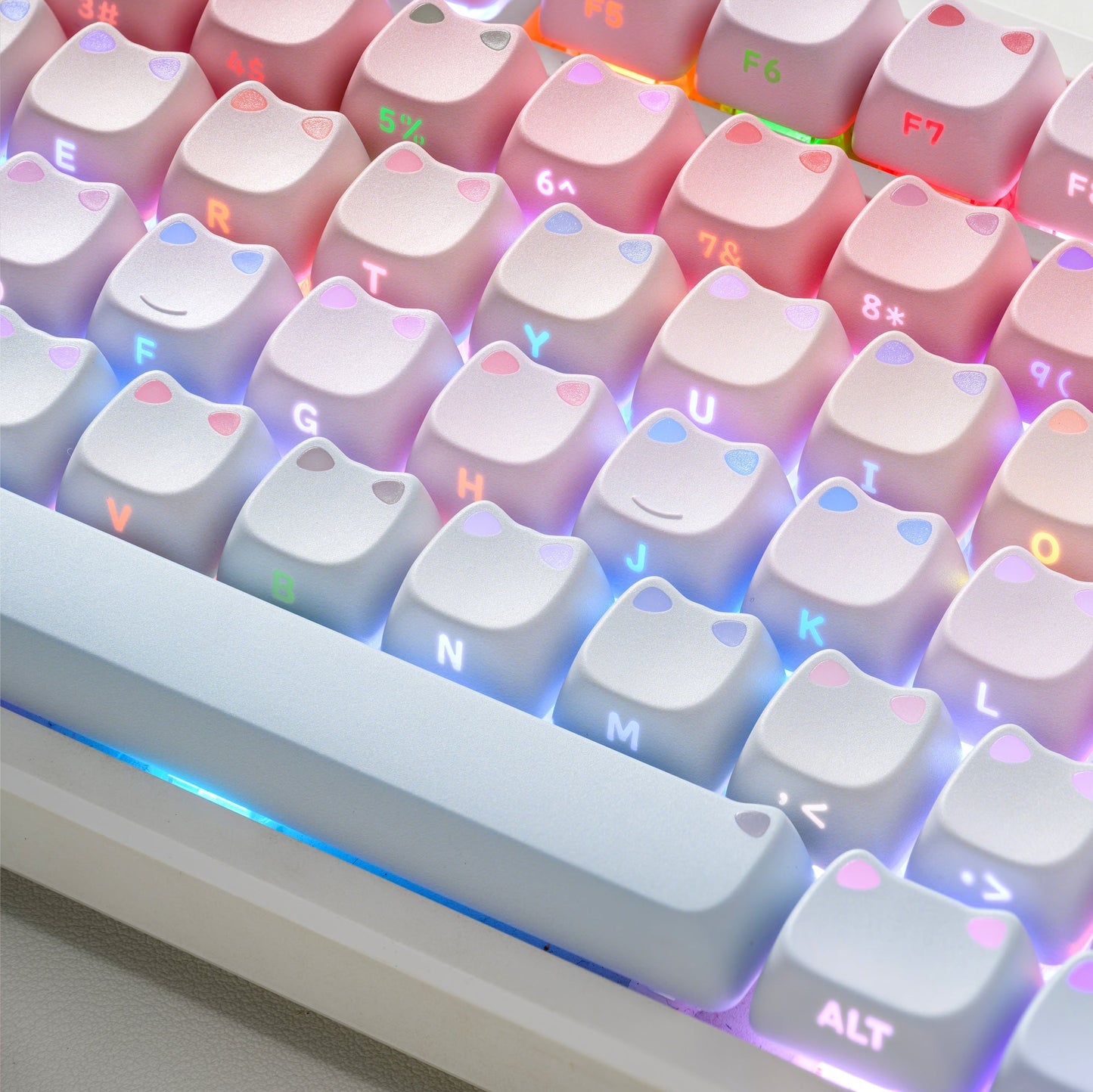 Pastel pink and blue keycap set with glowing shine-through legends in an angled view