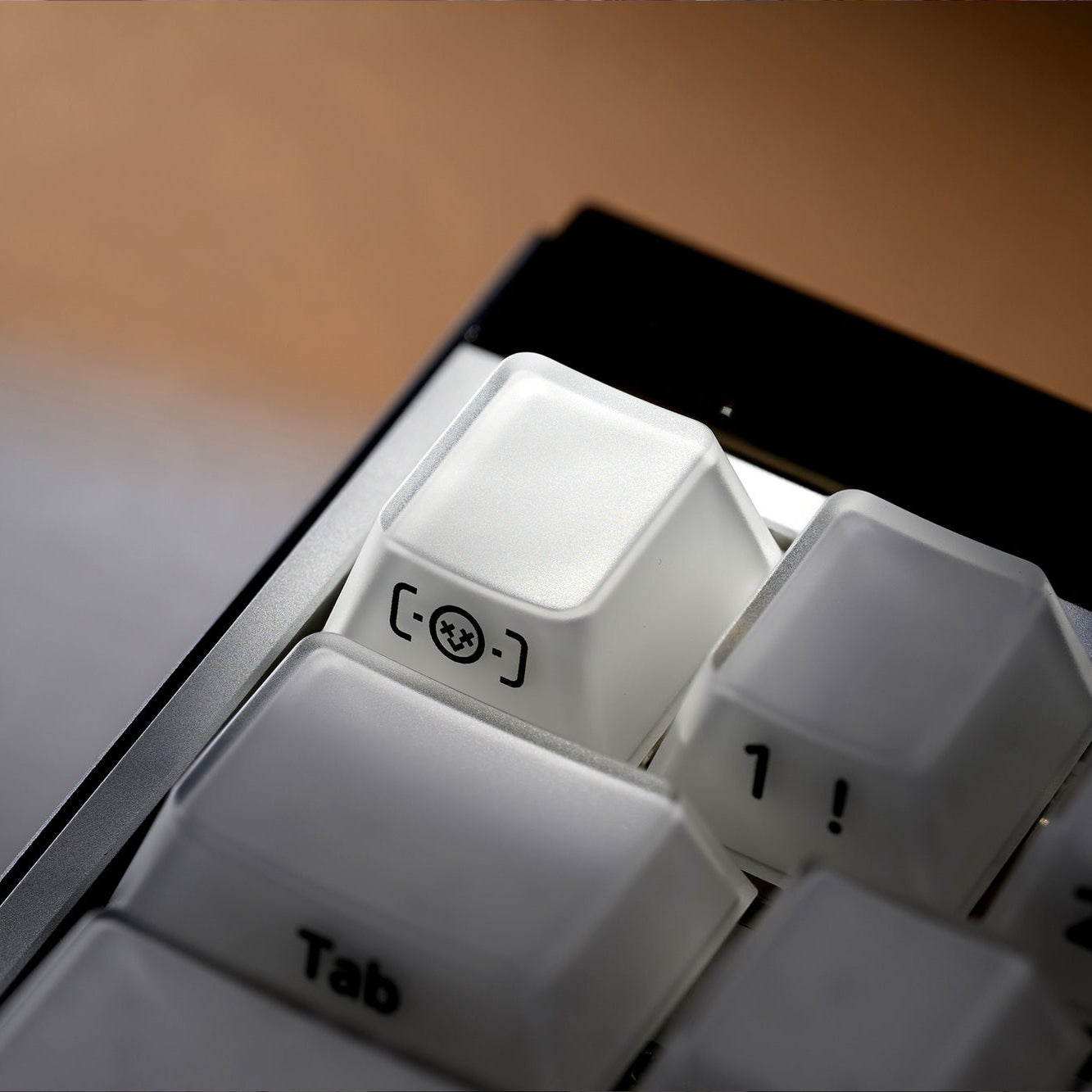 Single translucent keycap with blue-printed icon and number, white profile cap set.
