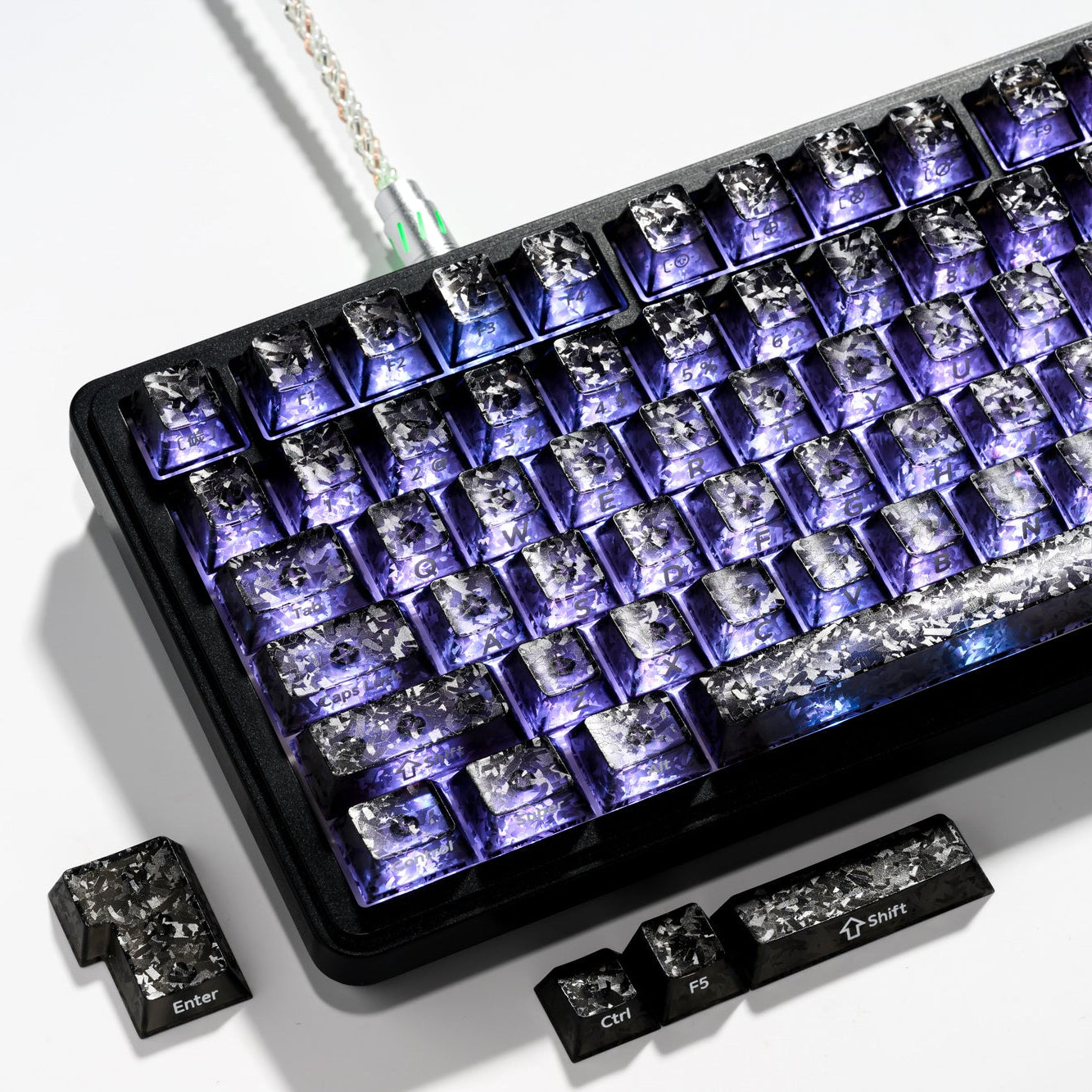 Smoke forged carbon-look PC keycap set with blue shine-through legends, key row close-up