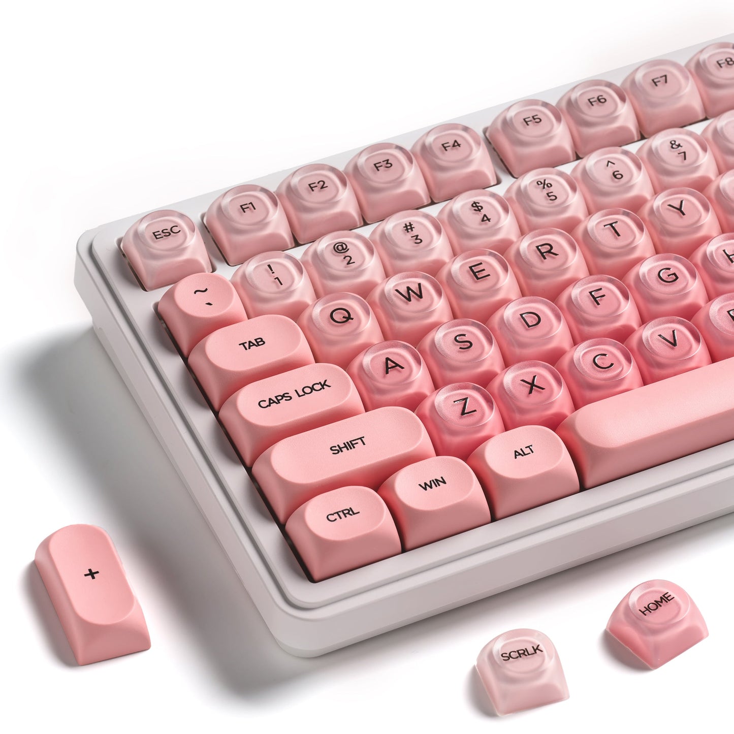 Blush pink keycap set on a light base with extra keycaps placed around the tray
