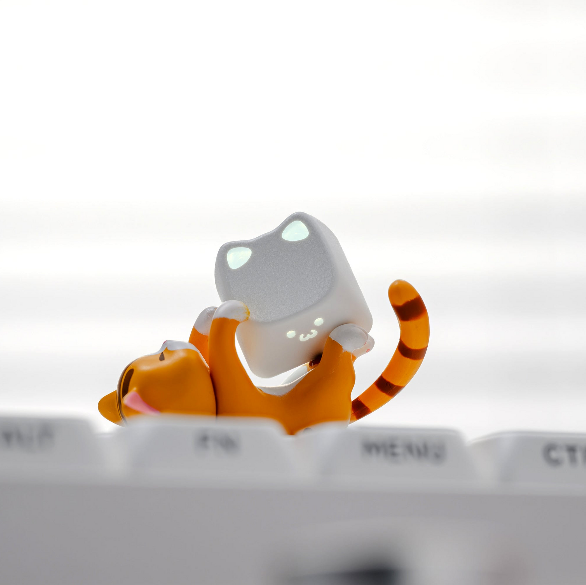 Dark gray keycap set with rounded sculpted caps and small cat figurine
