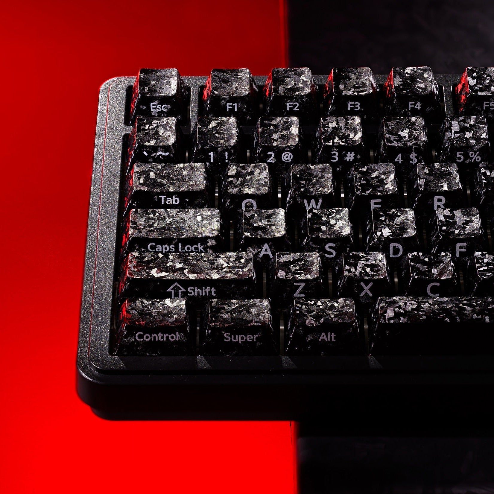 Black forged carbon-look PC keycaps on keyboard, side-printed legends visible on keys