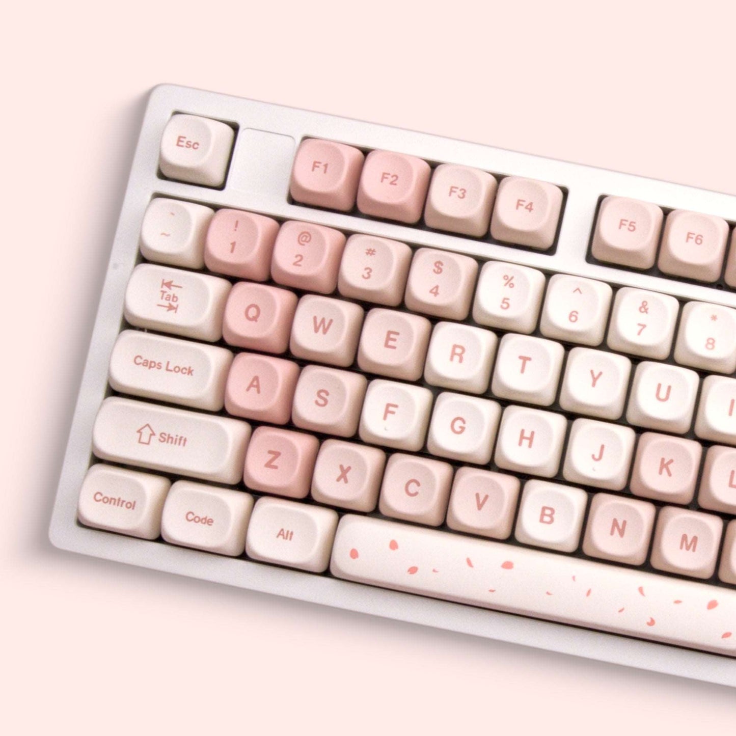 Cream and blush keycaps with labeled letters and small cherry blossom accents