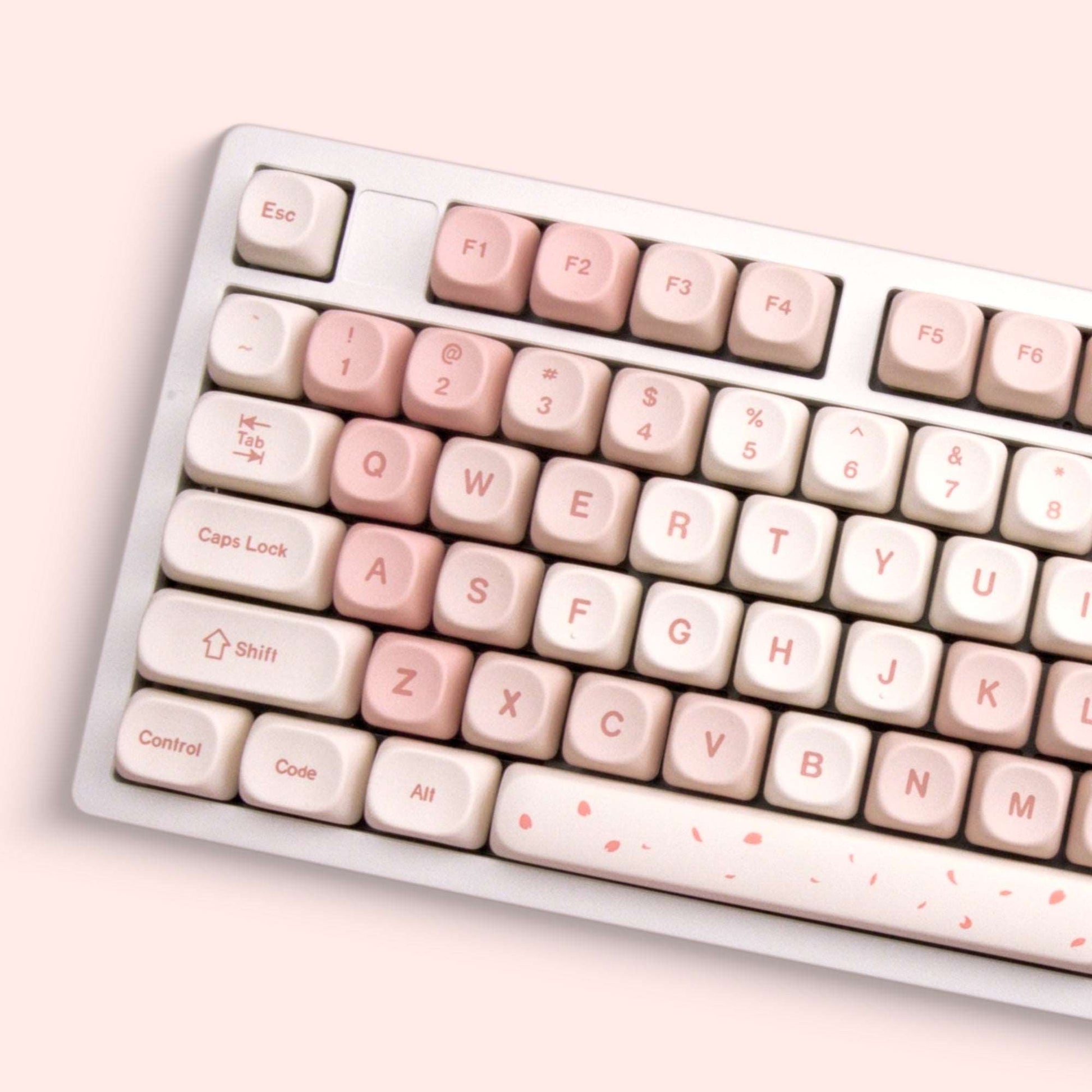 Cream and blush keycaps with labeled letters and small cherry blossom accents
