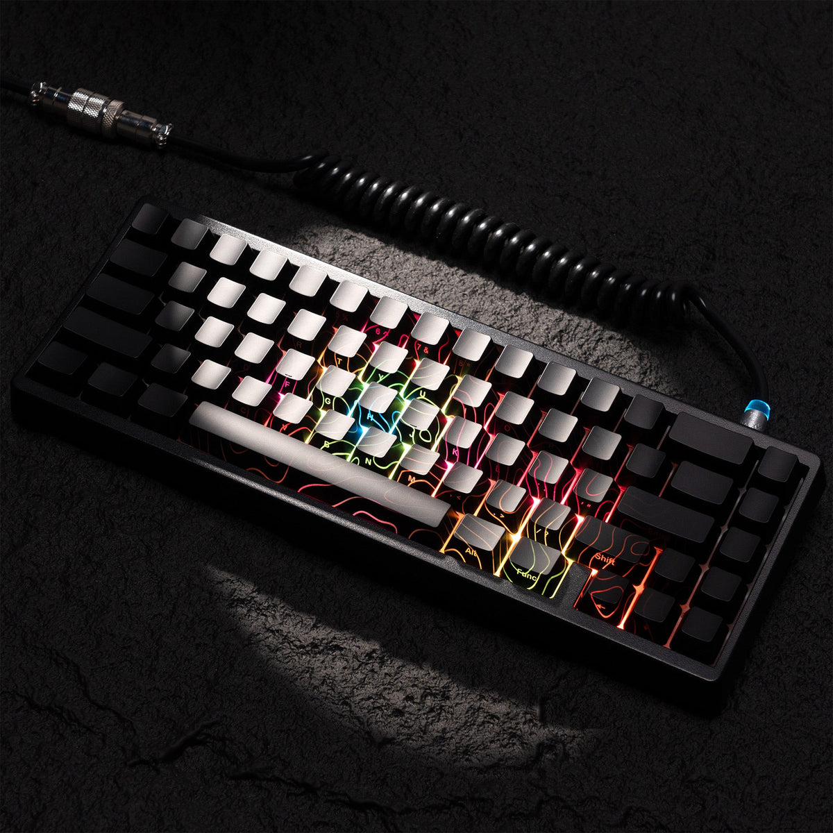 Black keycap set with glowing multicolor topographic shine-through pattern