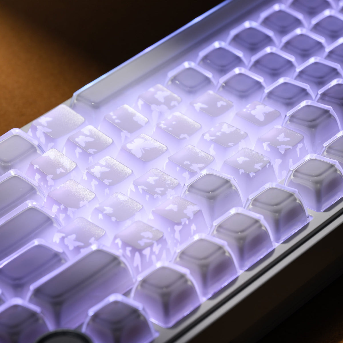 White transparent-feel keycaps with butterfly silhouettes under purple backlighting
