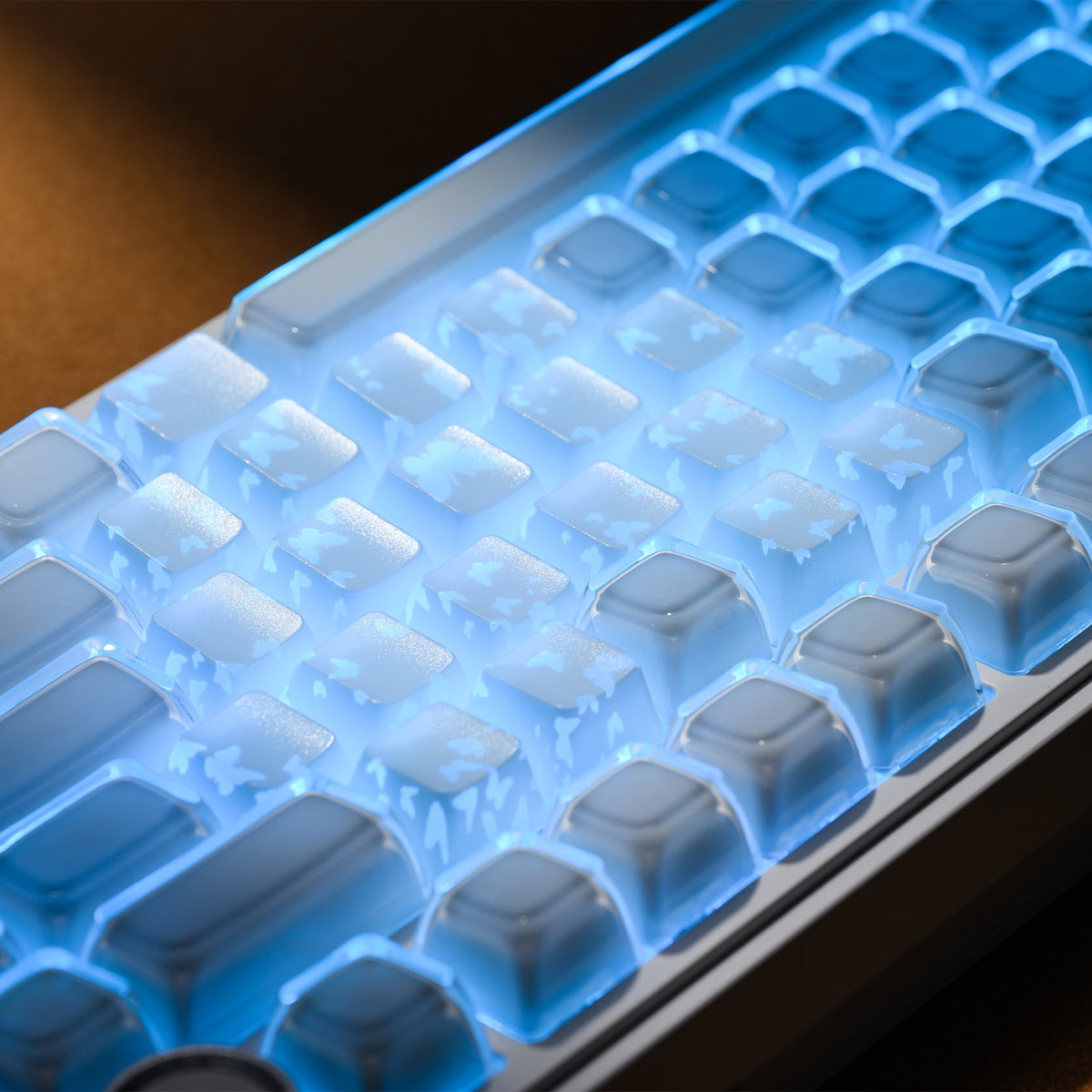 White keycaps with blue glow and butterfly cutouts spread across the top row area