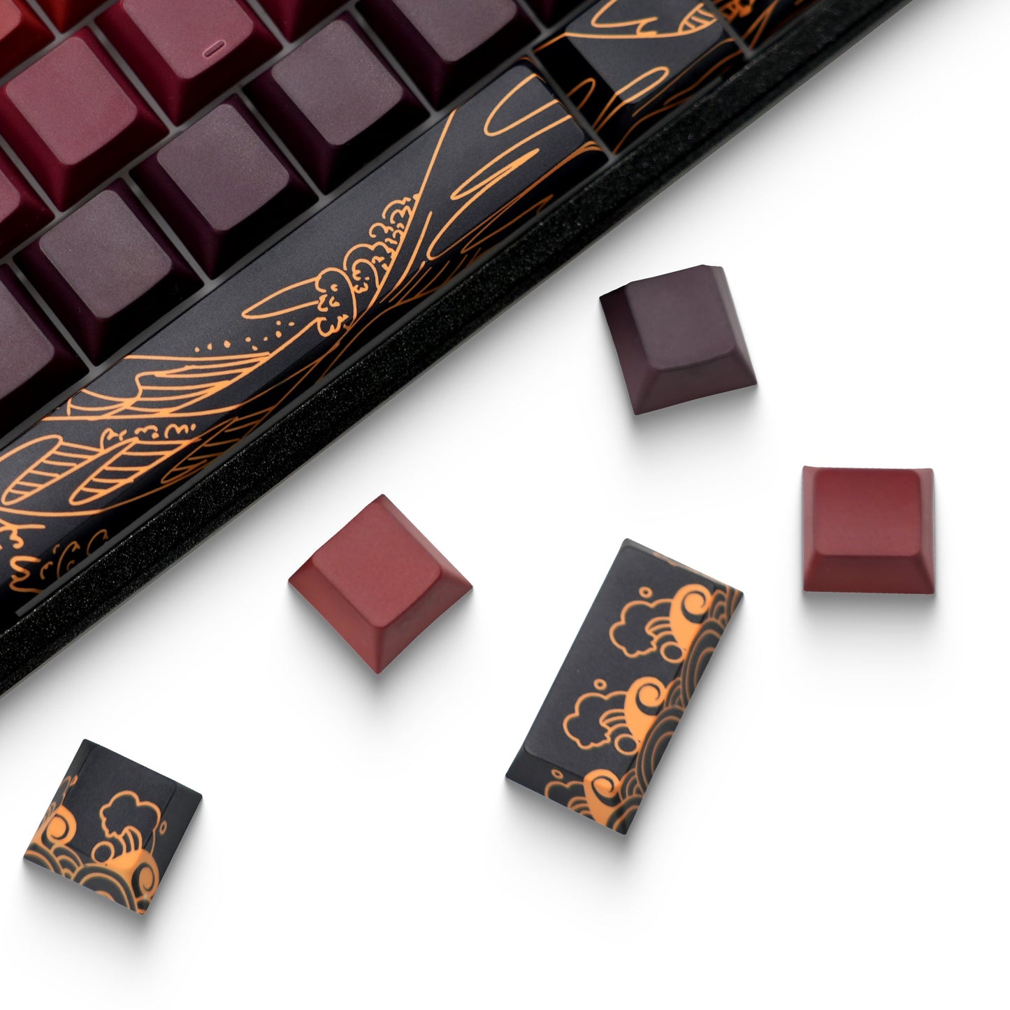 Red and dark keycaps with orange-gold side graphics shown with individual keycaps