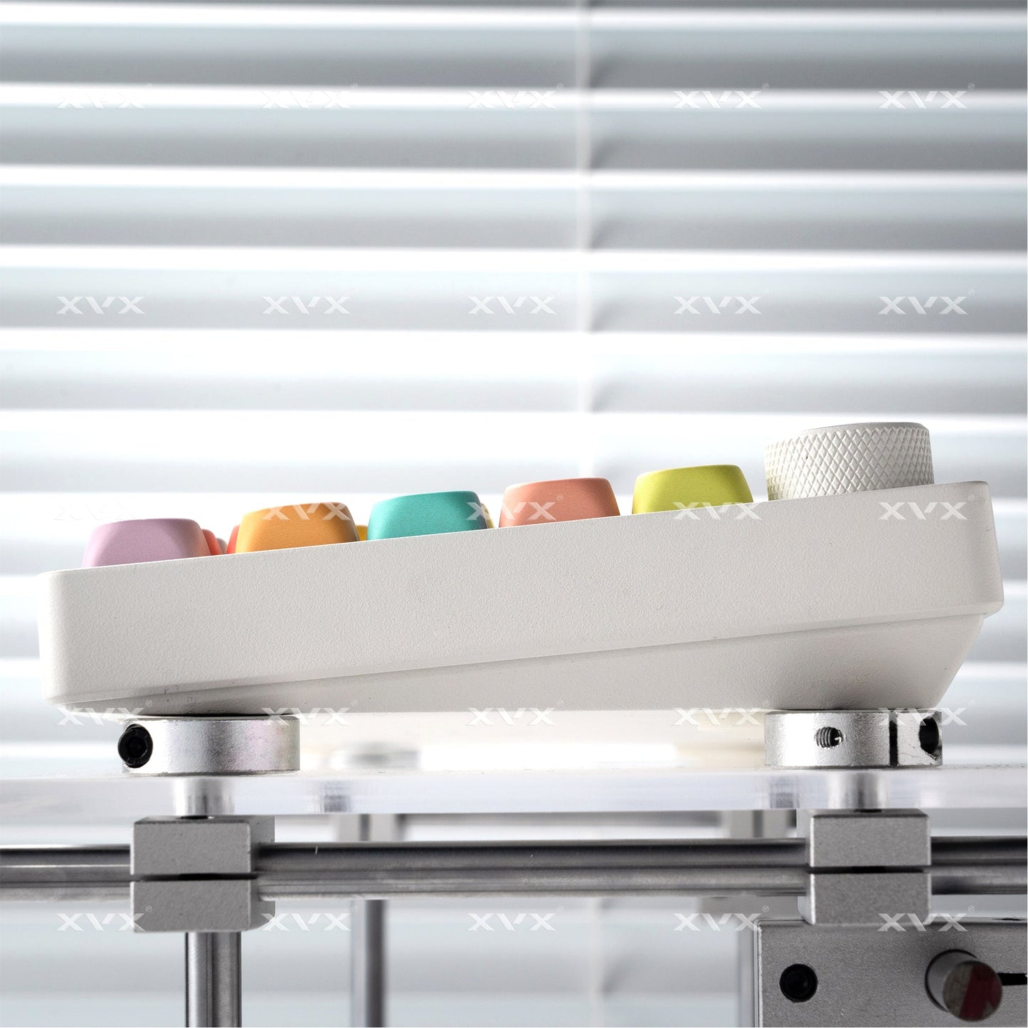 Keycap set mounted on a base during alignment, with pastel caps visible