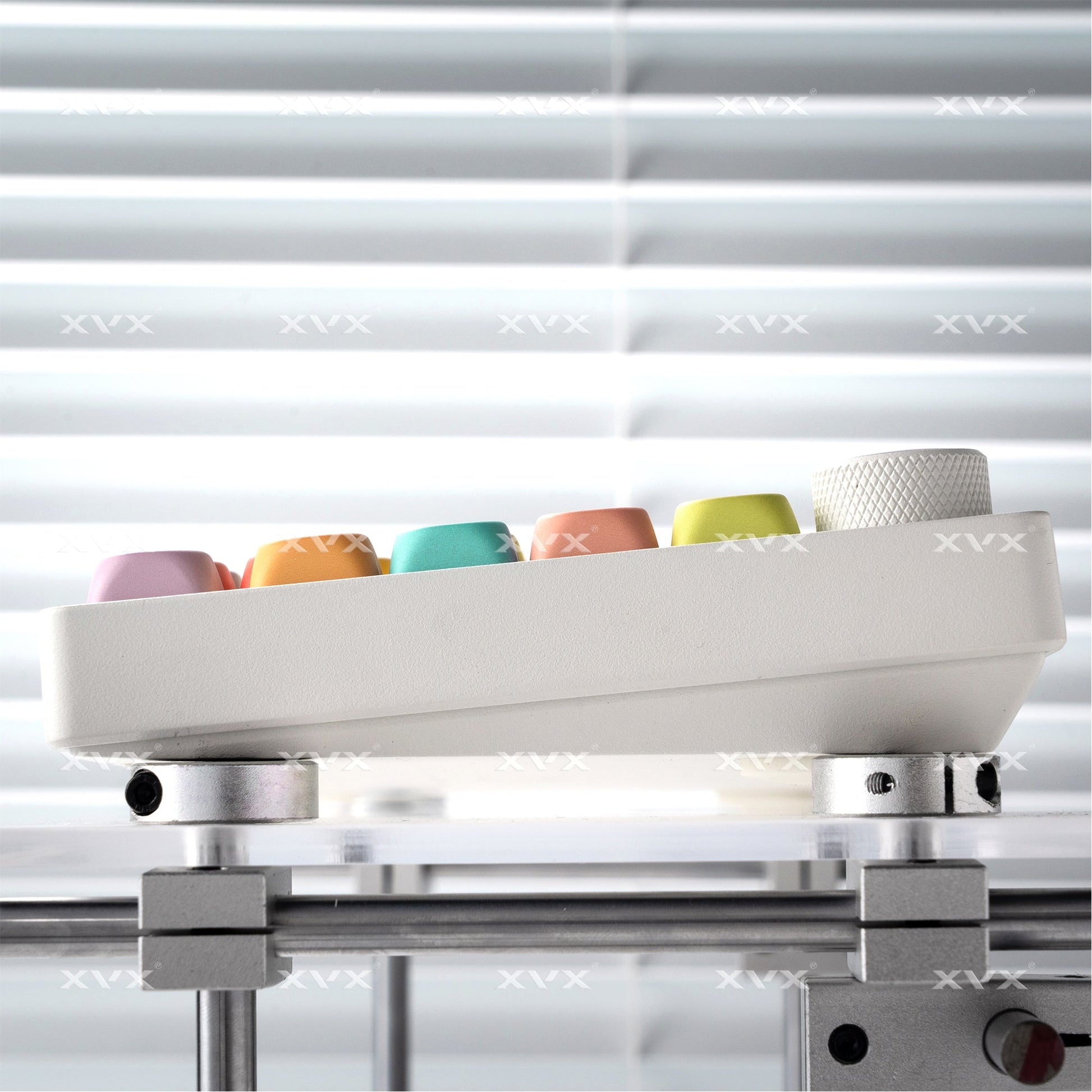 Keycap set mounted on a base during alignment, with pastel caps visible