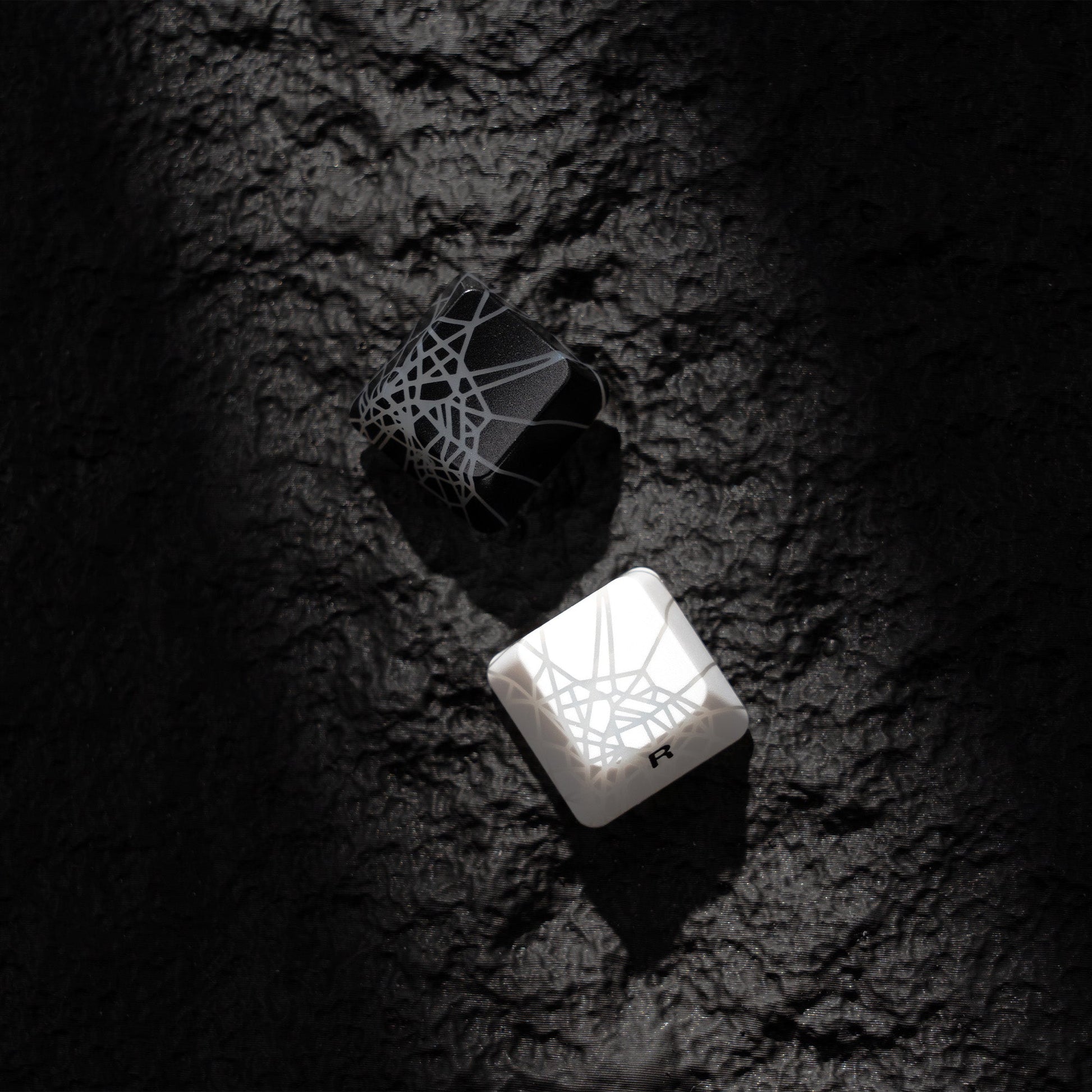 White keycap with spider-web shine-through texture and small character legends