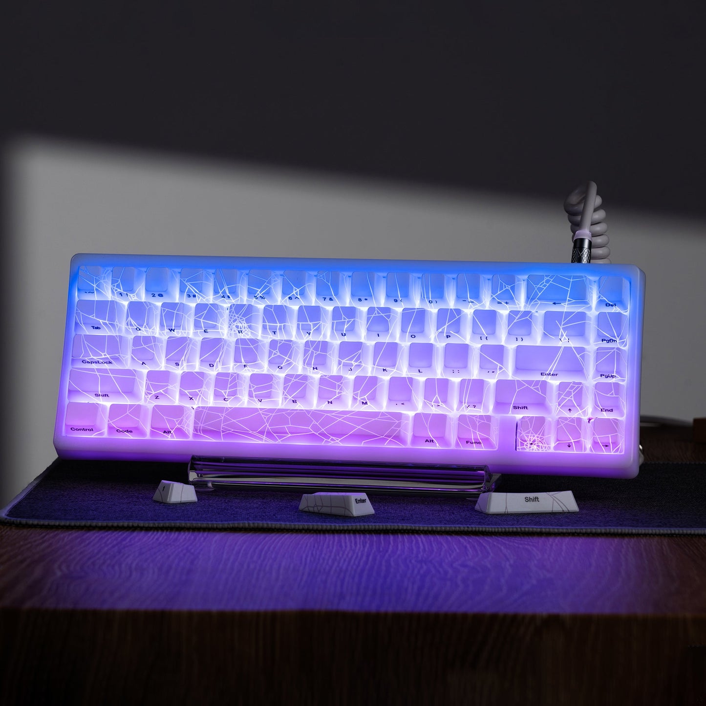 Purple and blue backlit keycap set with spider-web shine-through pattern