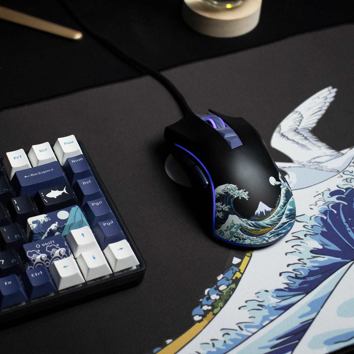 Black wired gaming mouse with purple side button glow, blue rim and wave artwork.