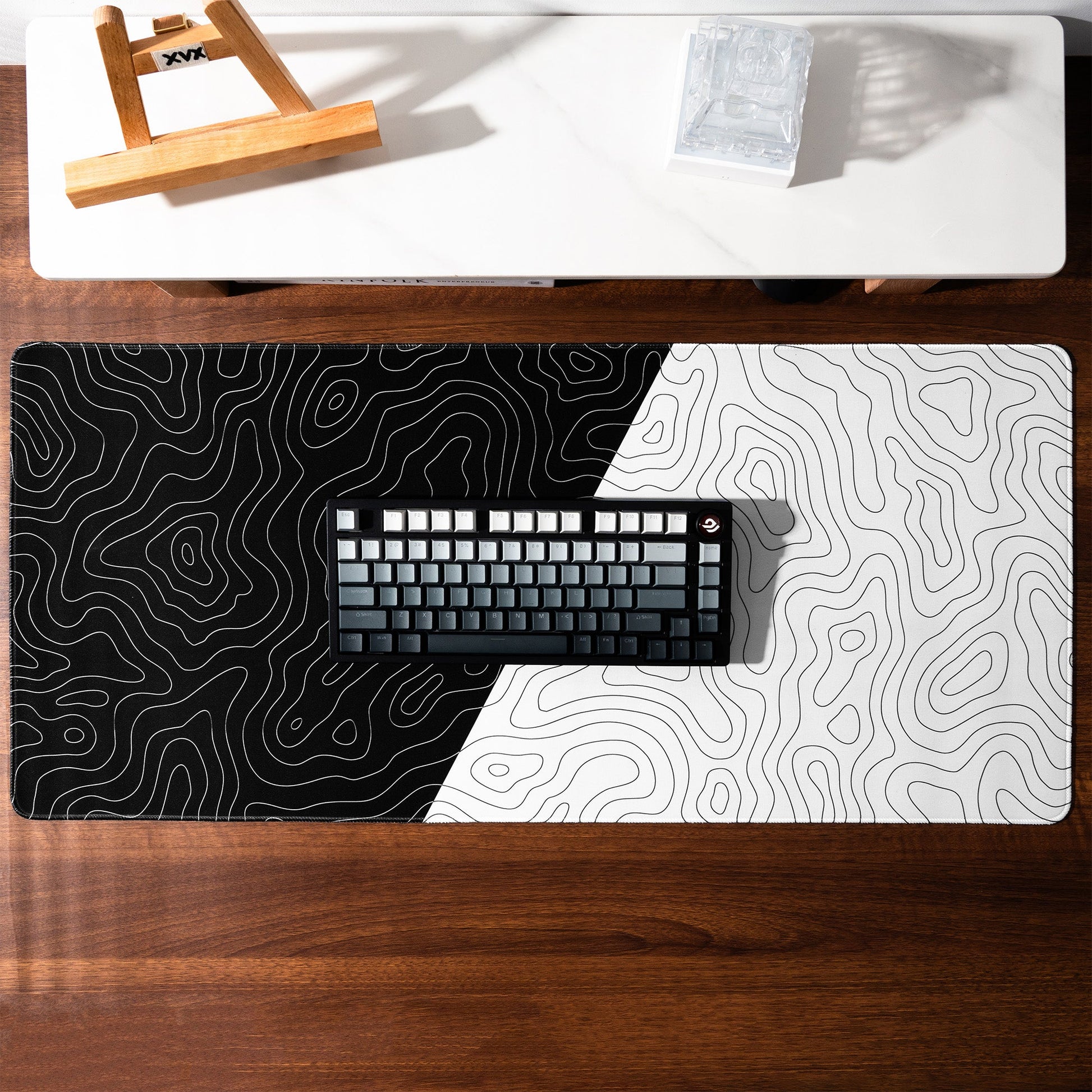 Topographic black-and-white desk mat with contour lines across the surface.