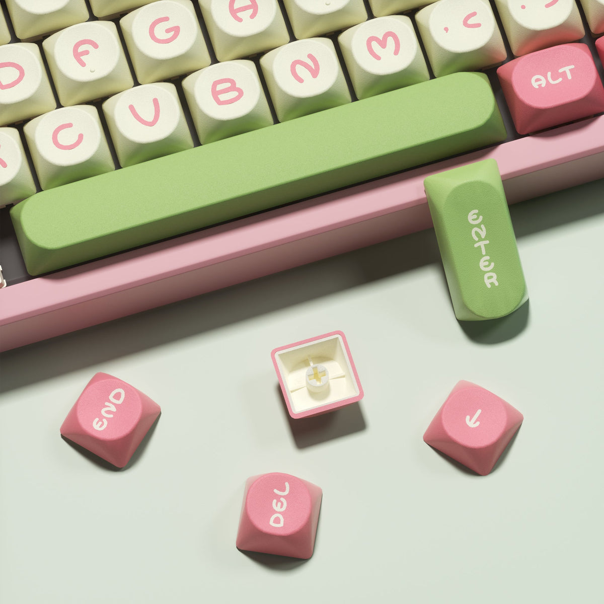 Close-up of green and pink keycaps with legends; includes pink utility and corner keys