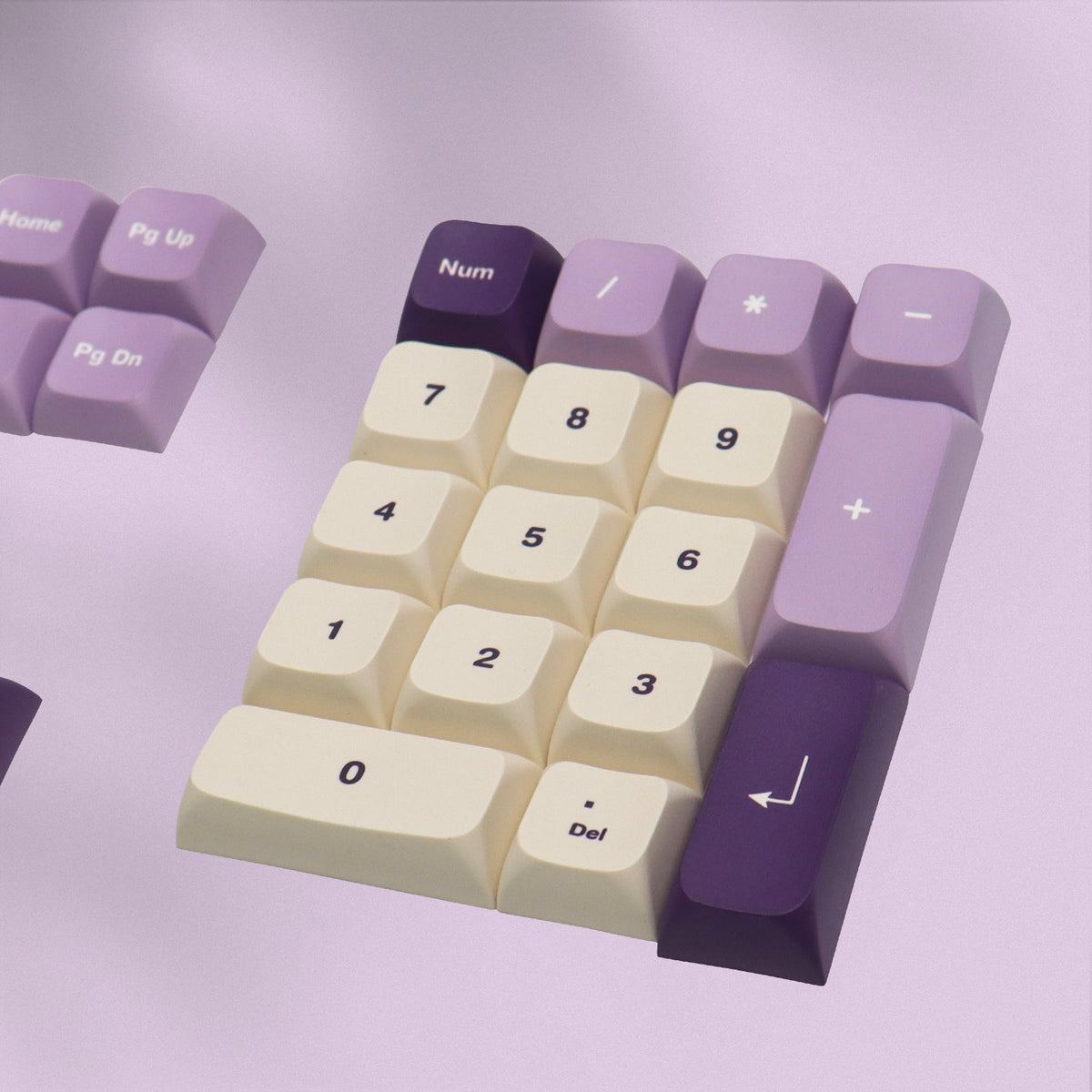 Numpad keycaps in lavender purple and cream with 0–9 and Delete legends