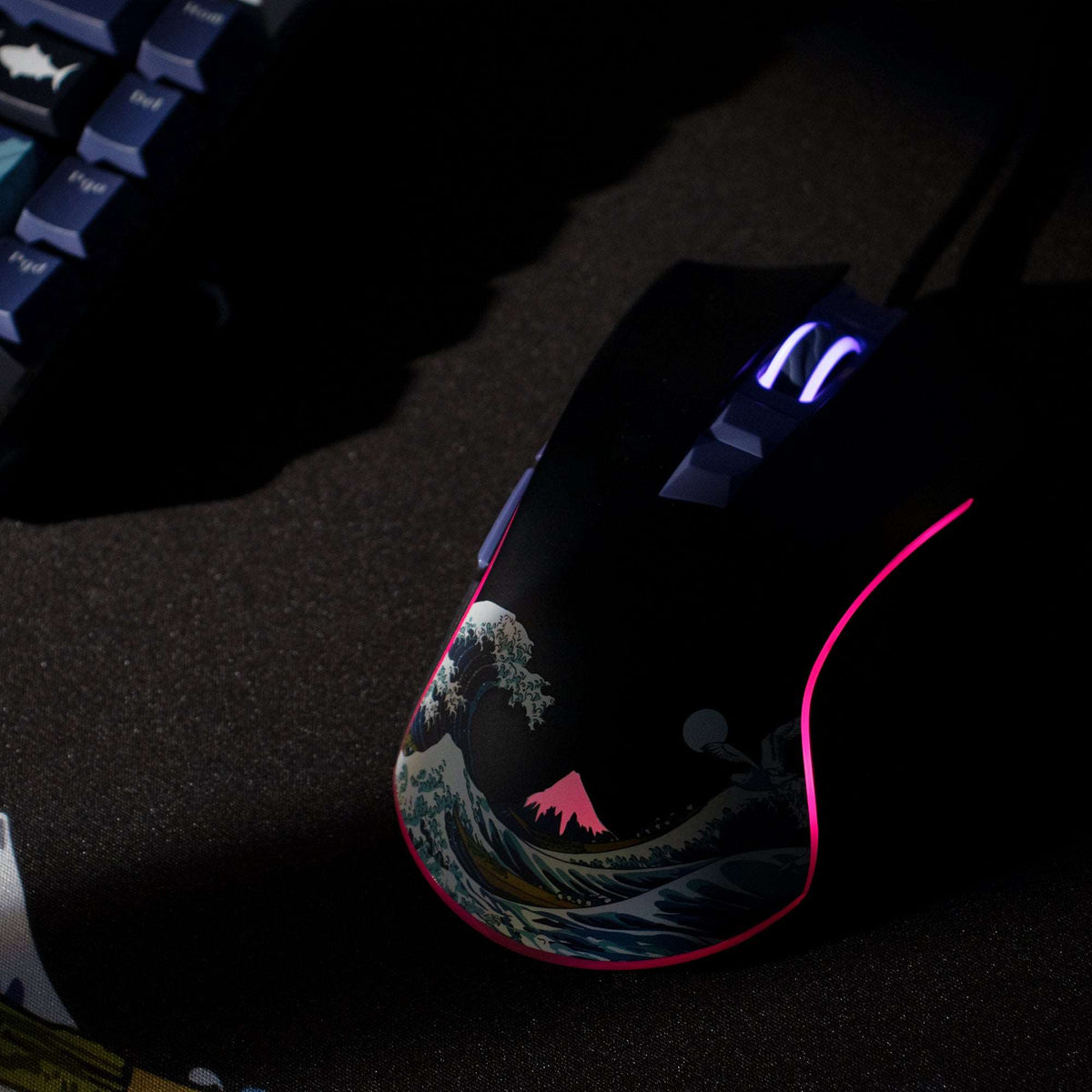 Black wired gaming mouse with purple-lit wheel and pink LED outline, wave graphic on body.