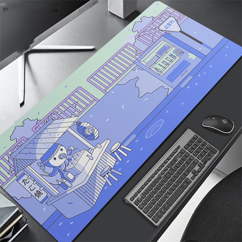 blue desk mat with cartoon design on a desk with keyboard and octopus.