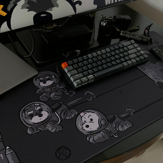 Black desk mat with cartoon space dogs and stars, stitched edge for mouse and keyboard