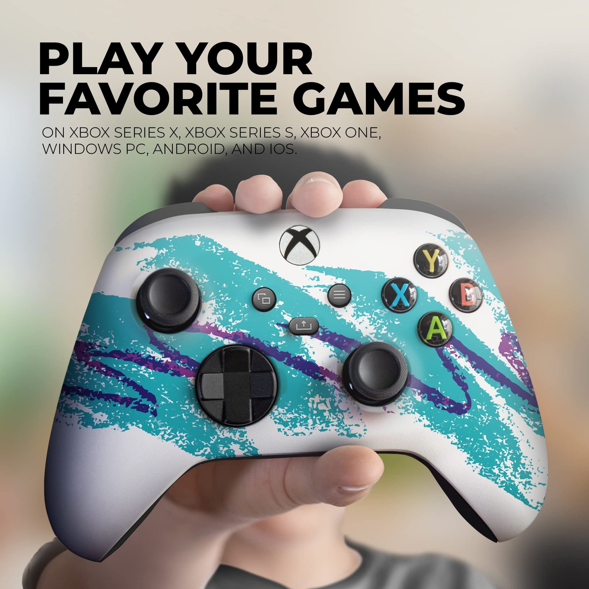 Xbox controller with teal splatter design in a hand