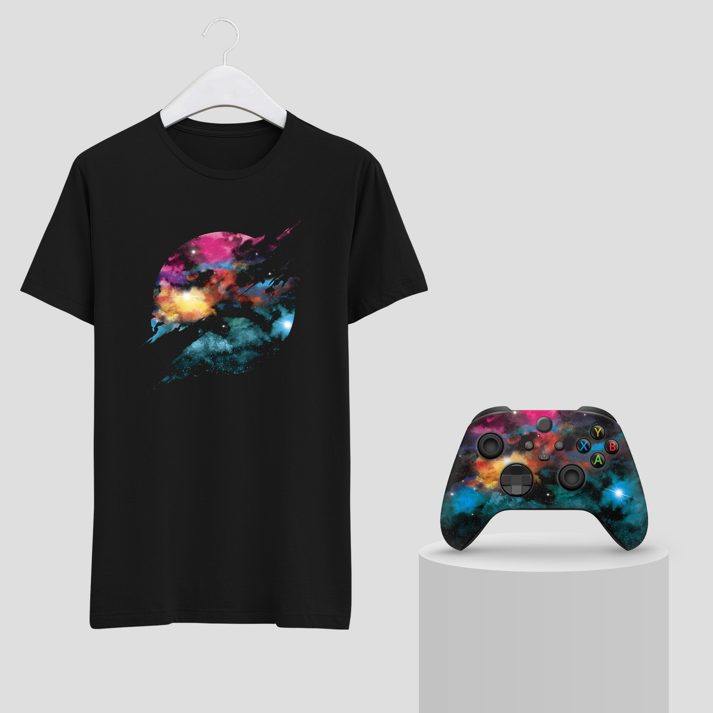 Black galaxy T-shirt on hanger with Xbox controller on pedestal, space nebula graphic