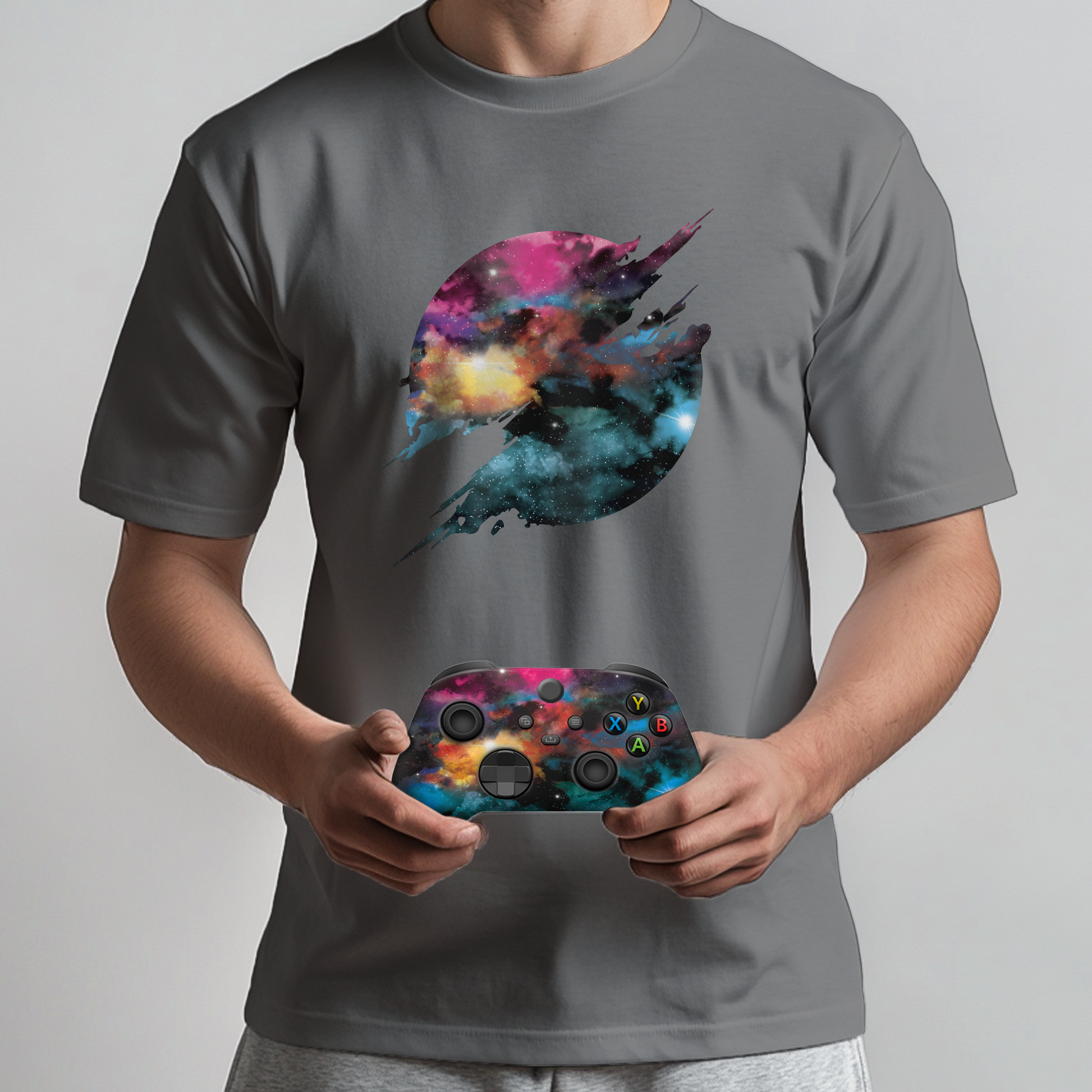 Gray T-shirt with galaxy jet graphic held by model, with Xbox Series X controller