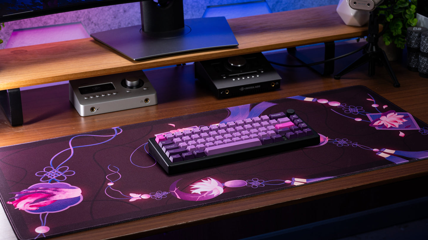 Rectangular desk mat with dark purple base and pink flower illustration and looping lines