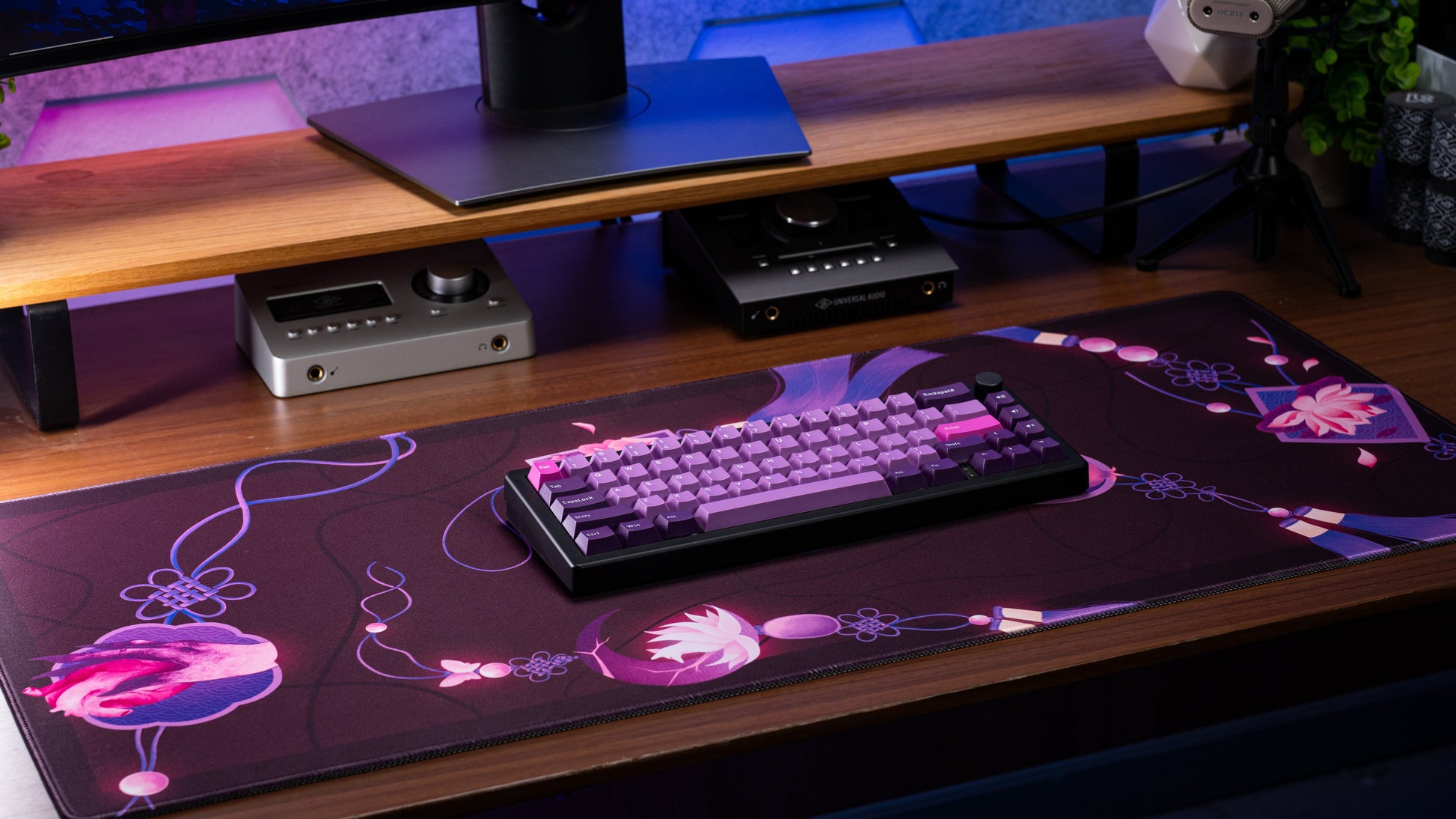 Rectangular desk mat with dark purple base and pink flower illustration and looping lines