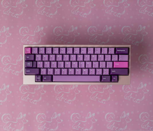 Pink desk mat with white corgi pattern, keyboard centered with purple keys