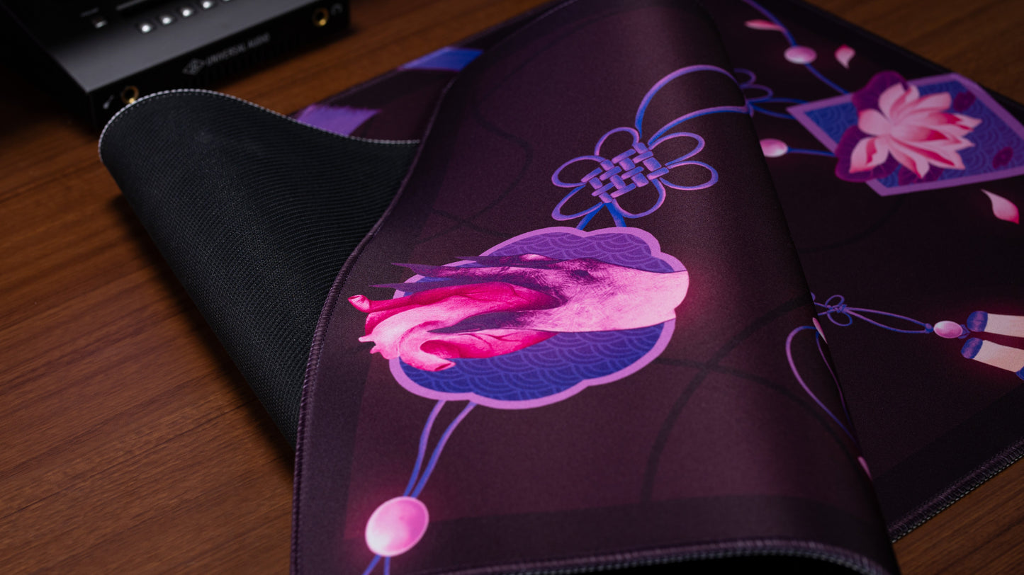 Rectangular desk mat edge close-up with dark purple floral artwork and stitched border