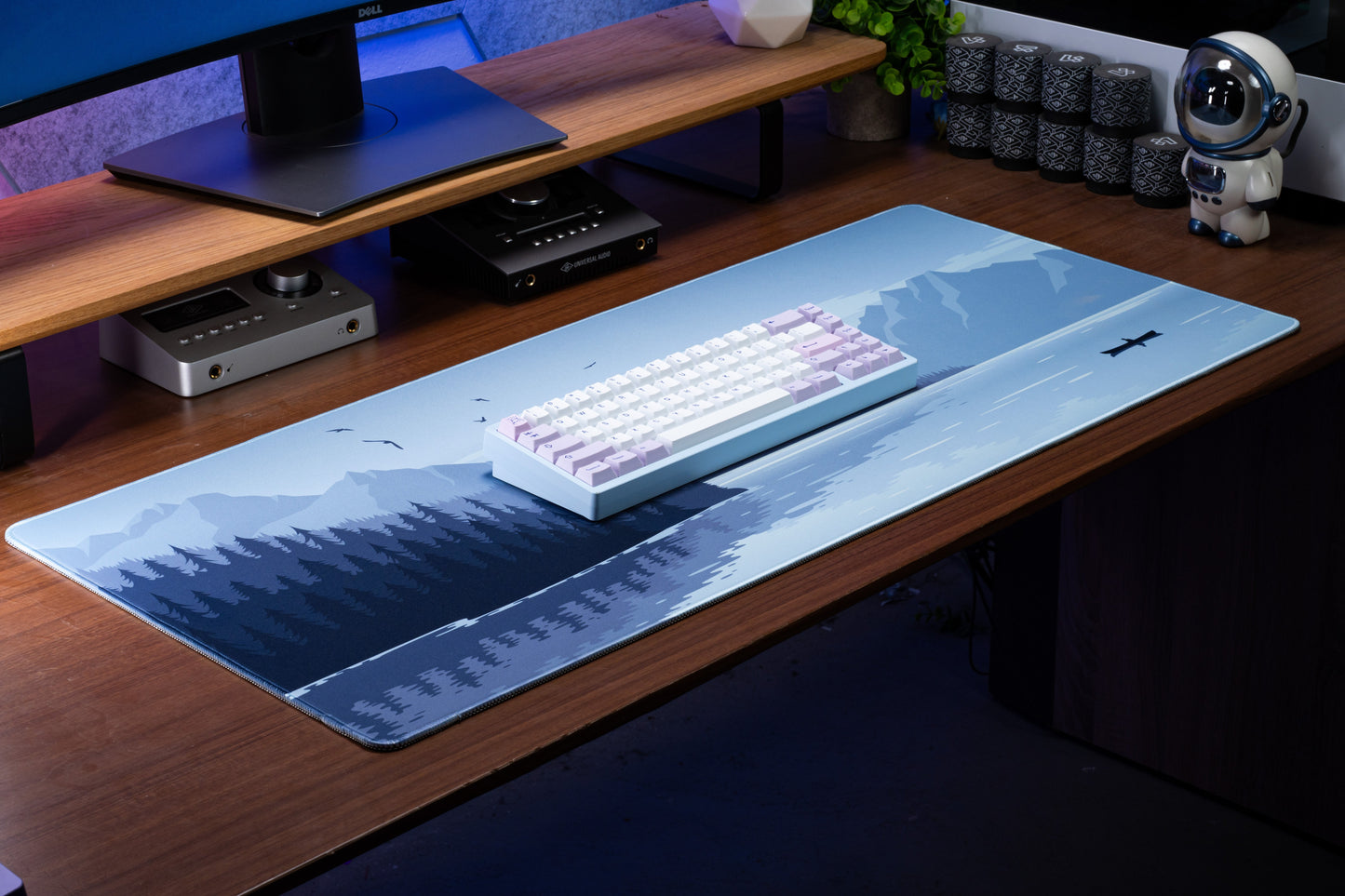 Blue desk mat with airplane and moon over mountain and forest graphics