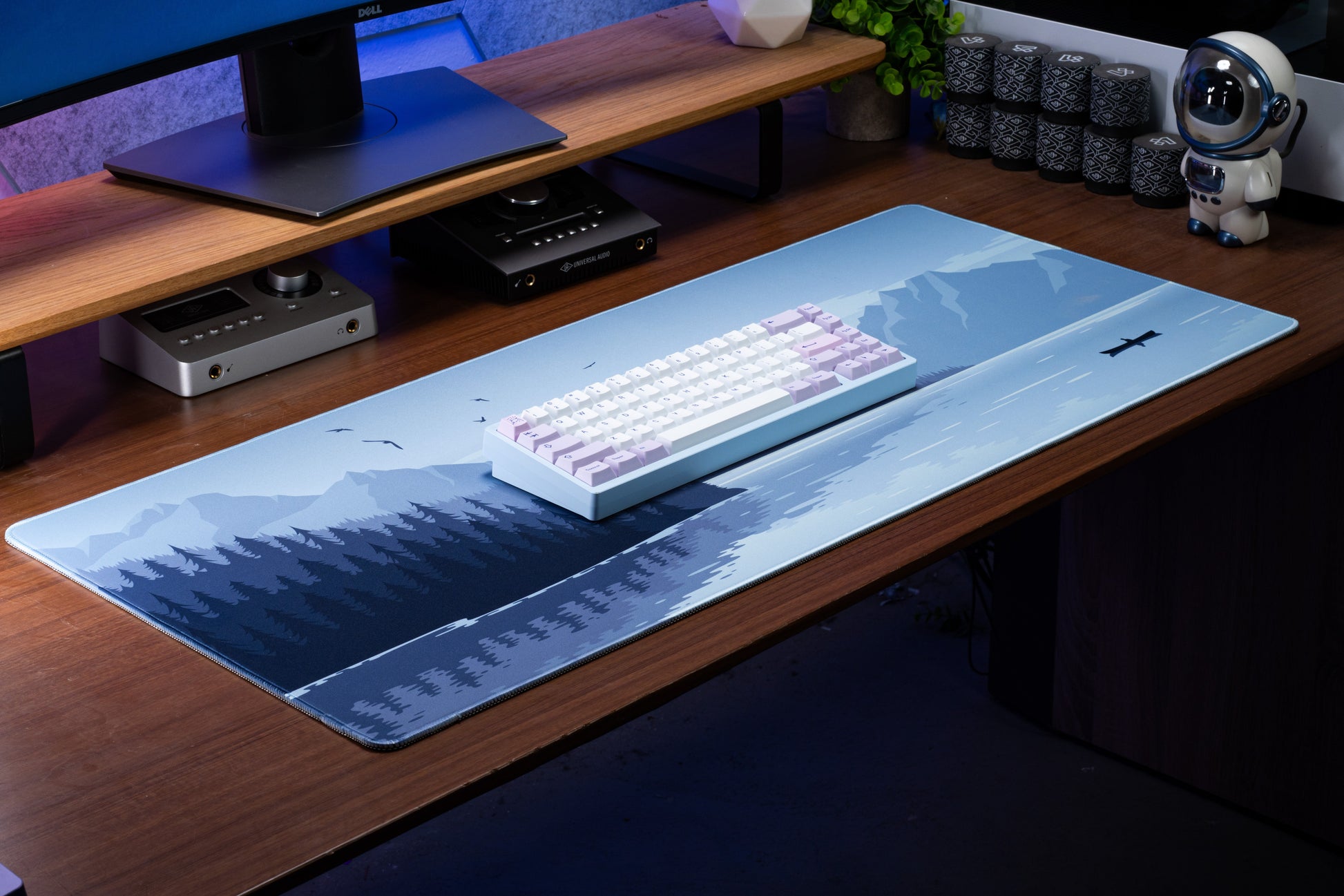 Blue desk mat with airplane and moon over mountain and forest graphics