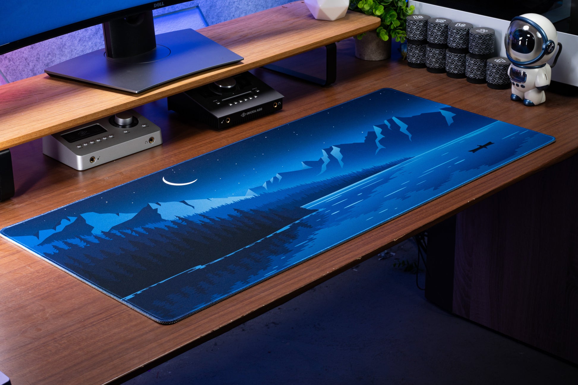 Blue desk mat with moonlit mountains and airplane trail graphic, wide surface
