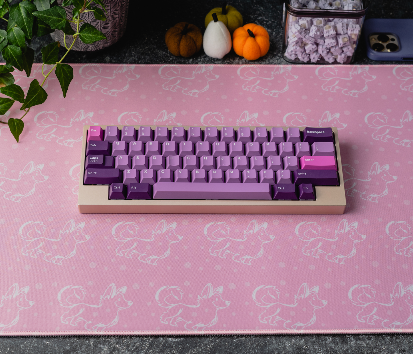 Pink corgi desk mat with white pattern, keyboard and pink stitched edge visible