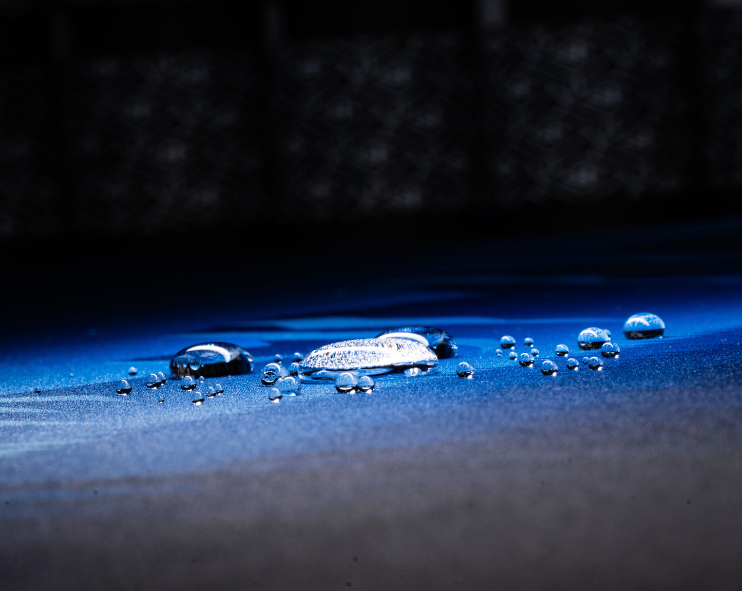Blue desk mat surface with water droplets on starry mountain print