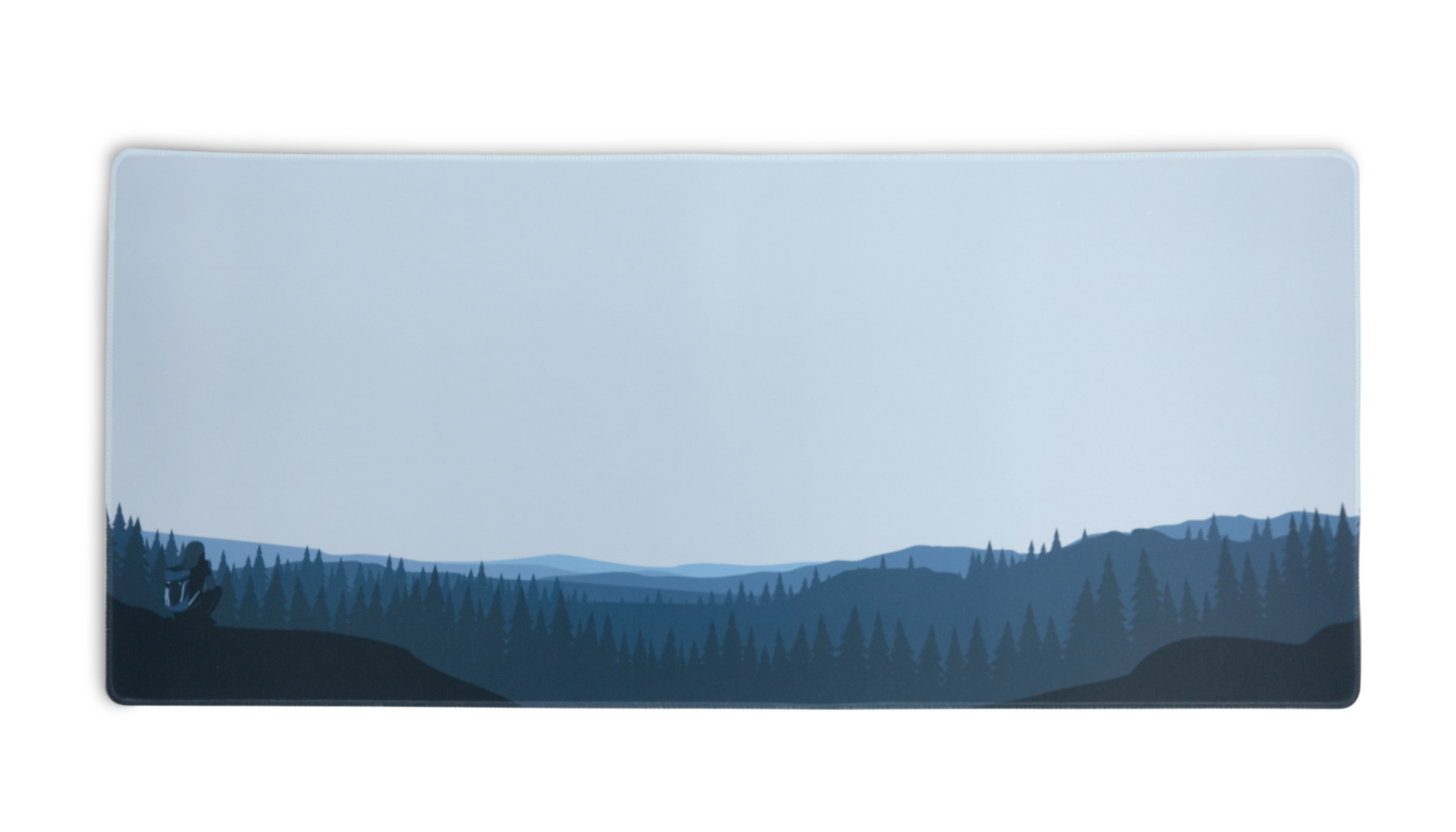 Rectangular desk mat with blue forest and hills graphic, stitched border