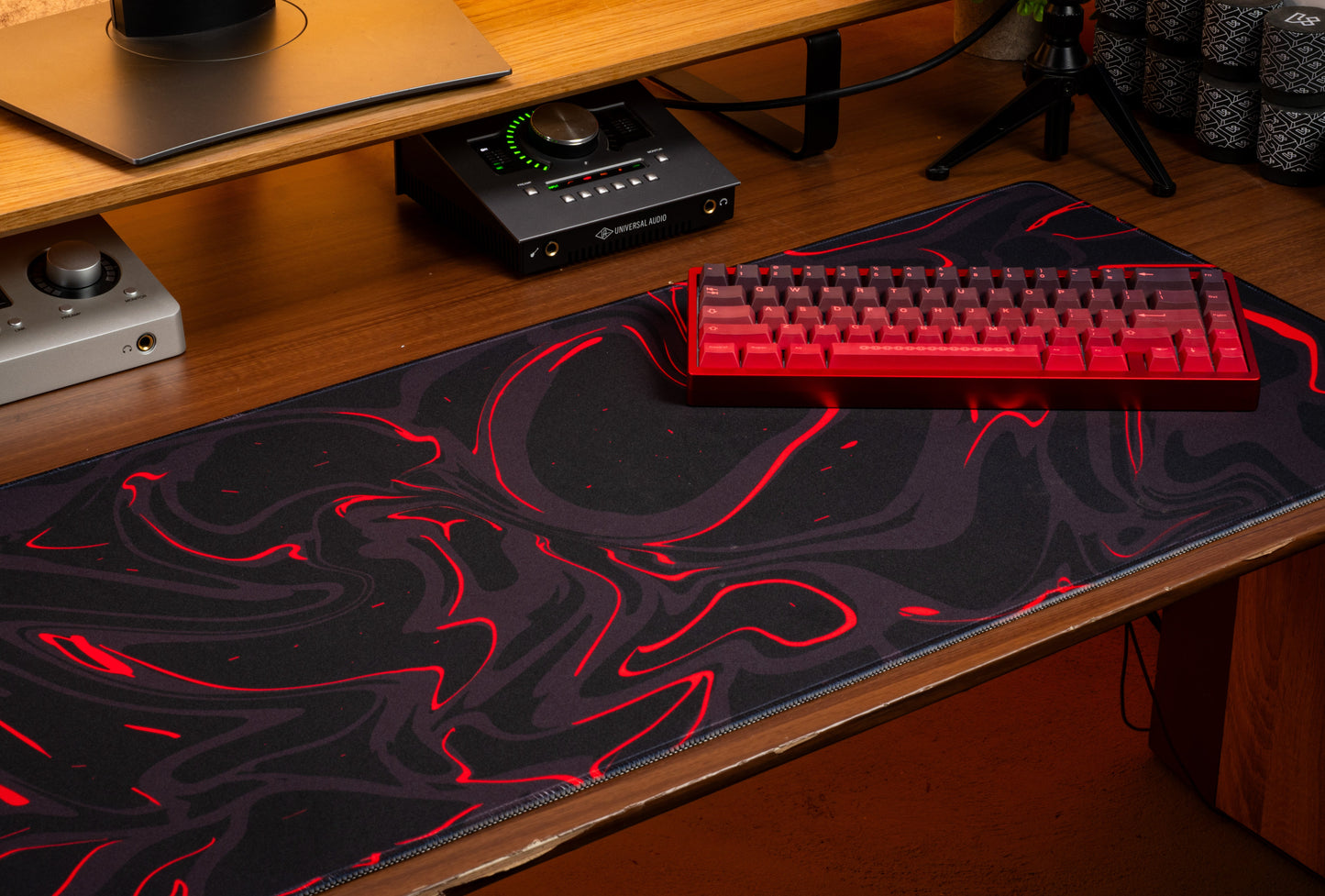Black desk mat with red marble swirl pattern and mechanical keyboard on top