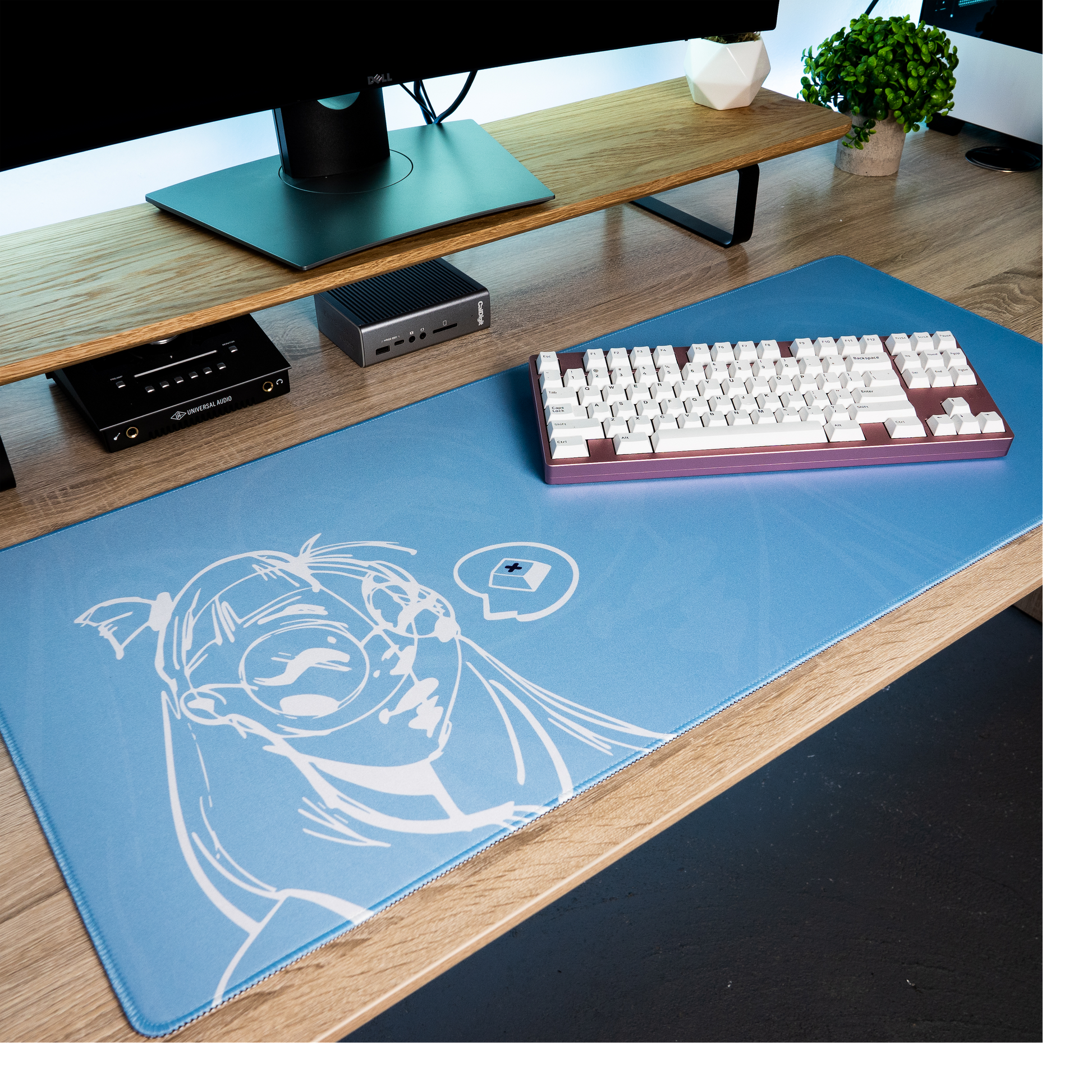 Blue desk mat with white anime portrait graphic under keyboard and mouse