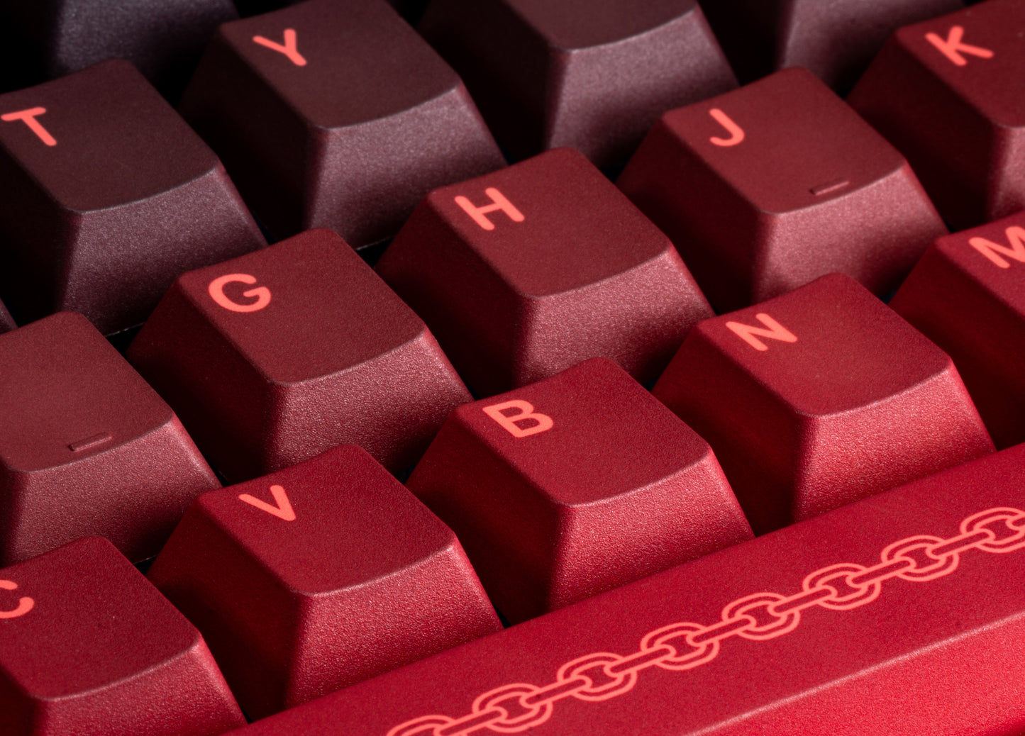 Maroon PBT keycaps close-up with chain motif on the spacebar