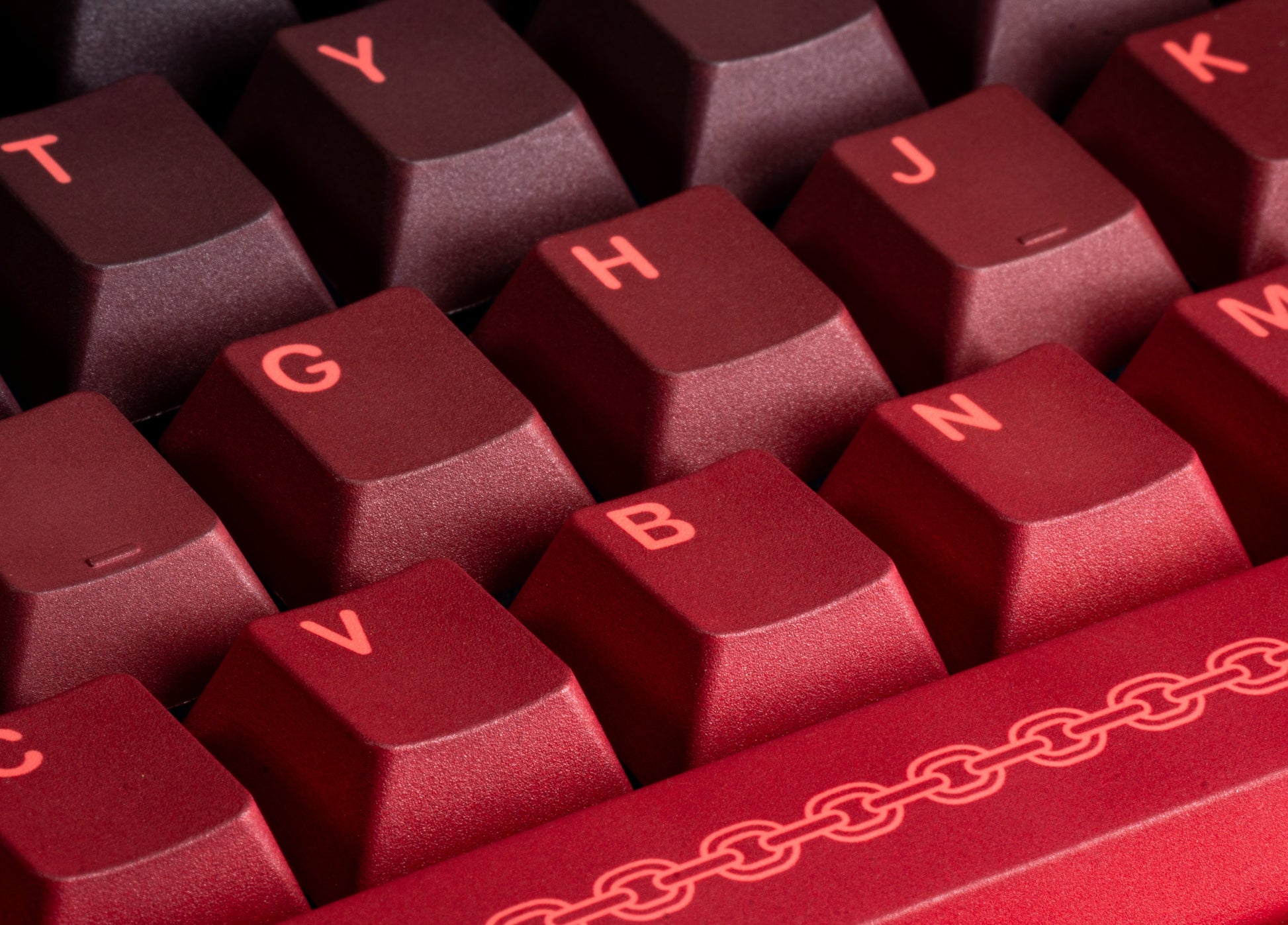 Maroon PBT keycaps close-up with chain motif on the spacebar